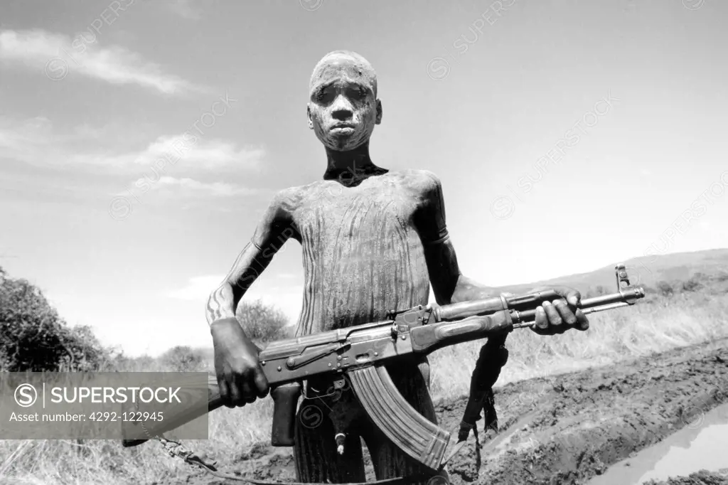 Africa, Ethiopia, South Omo, Mago National Park, Mursi man with body painting and AK47 rifle