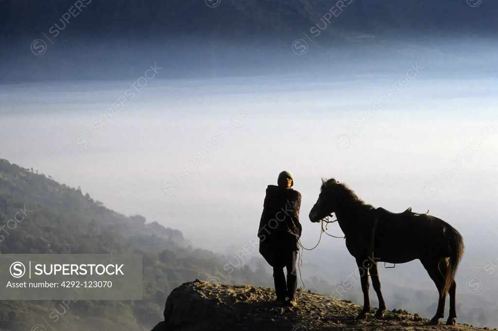 Indonesia, Java. Man with horse at the foot of Mt. Bromo volcano