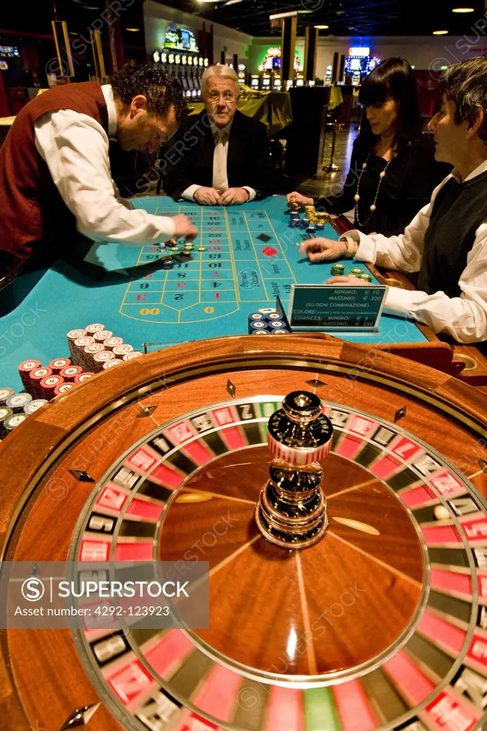 Italy, Val D'Aosta, Saint Vincent, people gambling at roulette table in casino