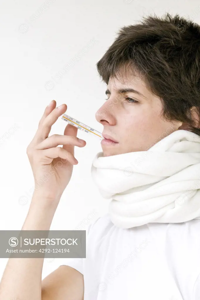 Teenage boy with thermometer in mouth