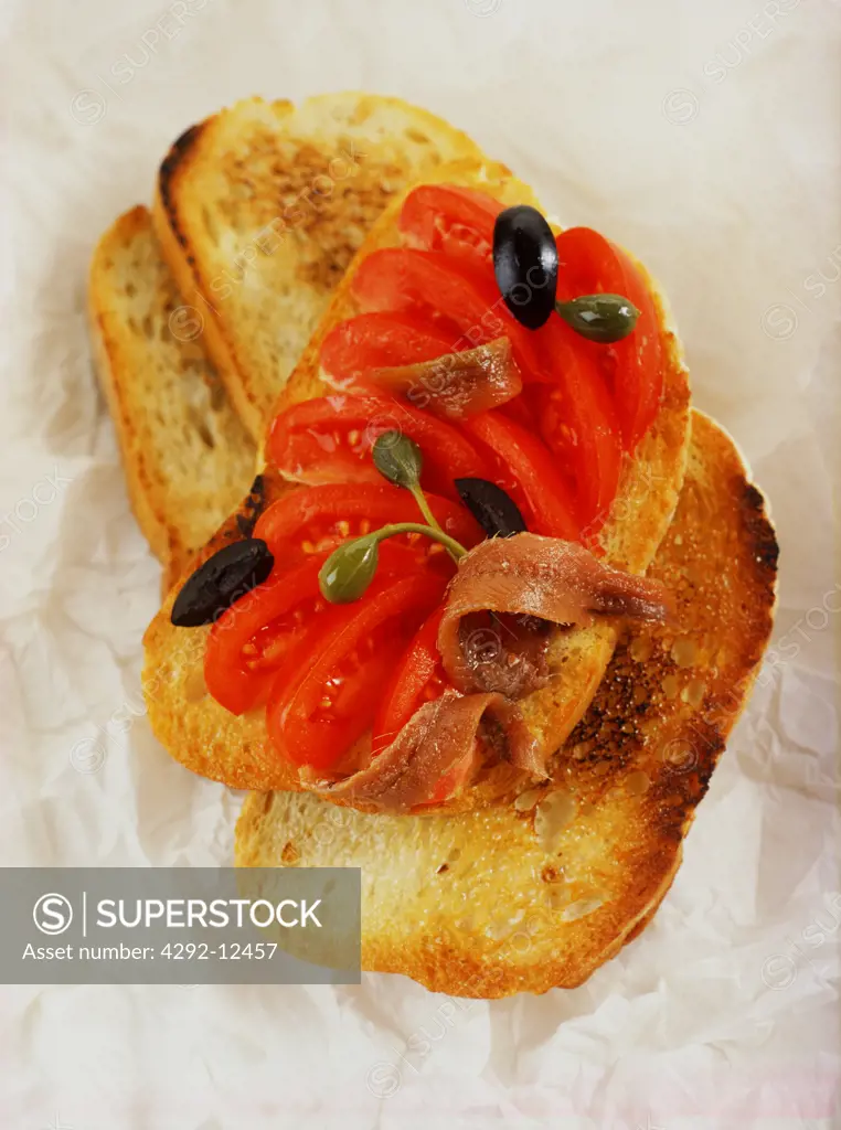 Bruschetta - toasted bread with tomato, olives, caper and anchovy