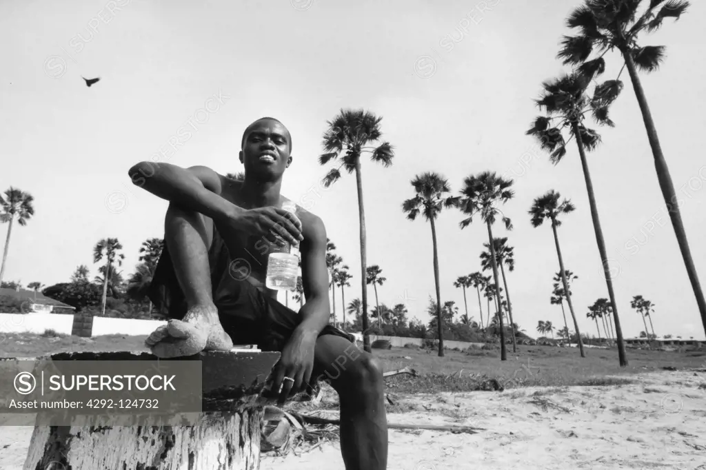 Africa, Gambia, Kuto, man sitting on pier