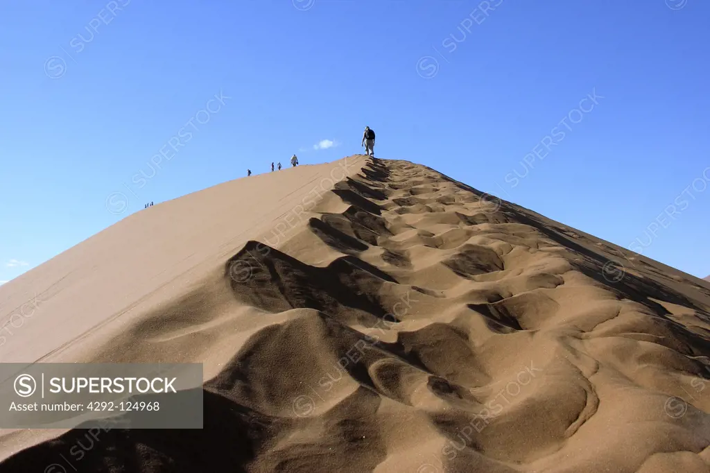 Africa, Namibia, people climbing dune in the desert