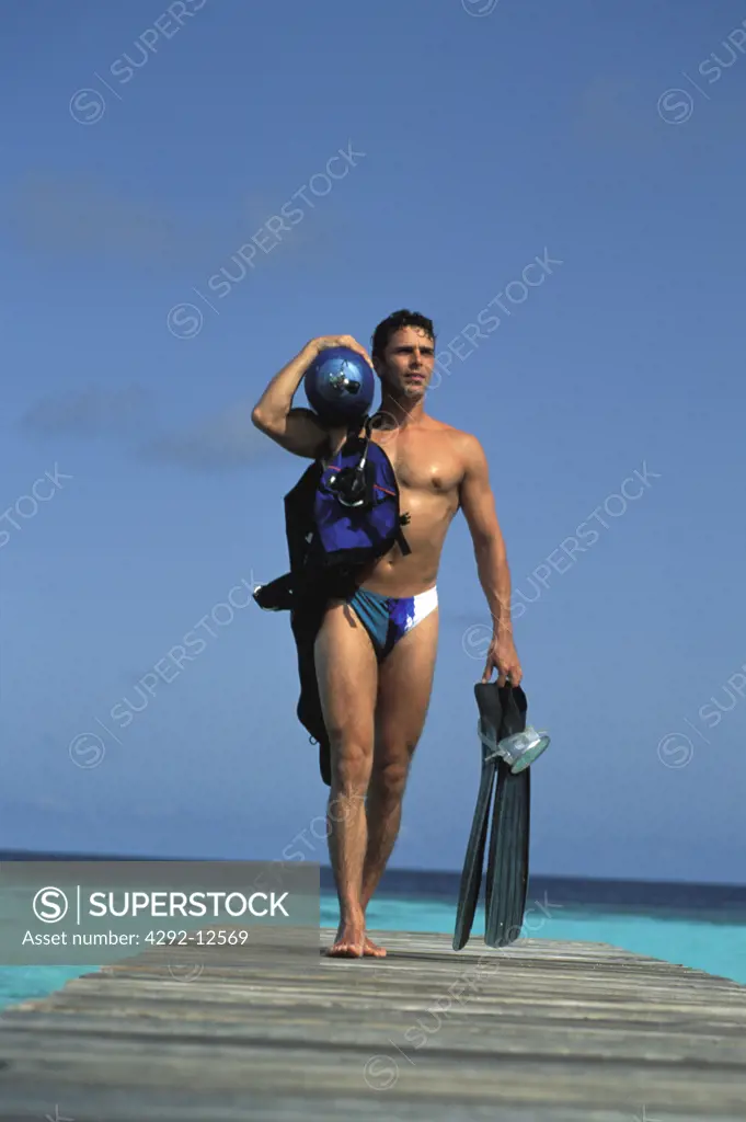 Young man carrying diving equipment