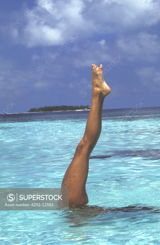 woman diving with legs up, exercising in the sea, close up, agility