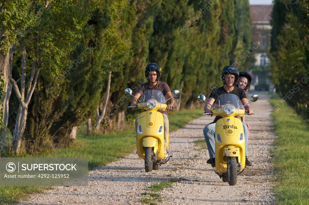 Teenagers riding Vespa scooter