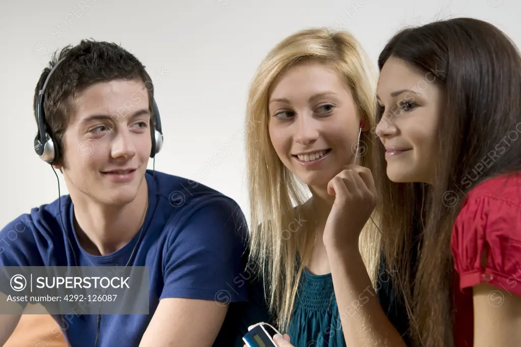 Three friends listening to music with mp3 player