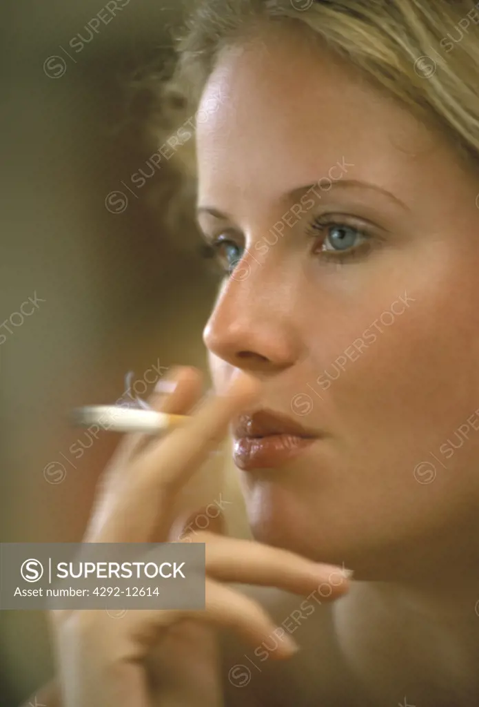 Portrait of young woman smoking close up