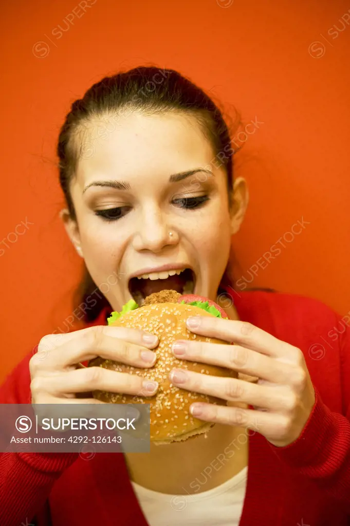 Teenage girl eating hamburger