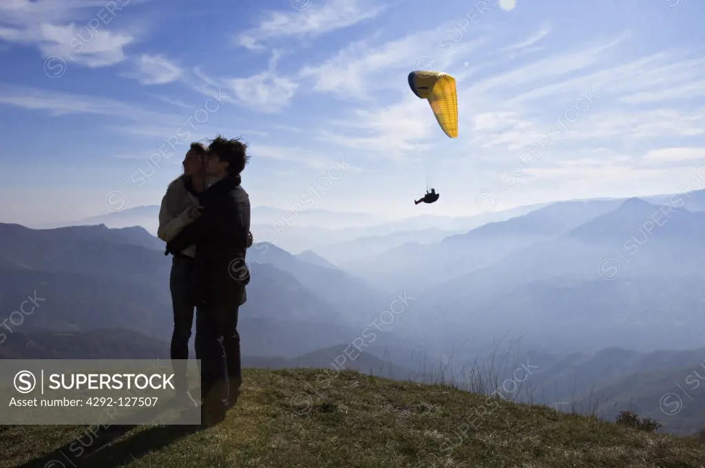 Italy, Marche, Sibillini Mountain National Park, young couple on top of a mountain embracing