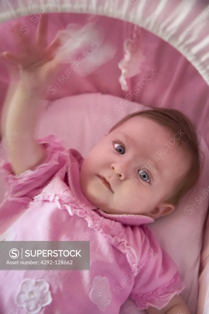 Portrait of baby girl lying in crib