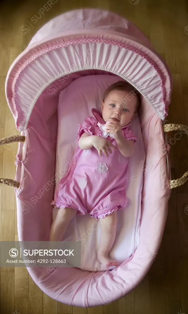 High angle view of baby girl lying in crib