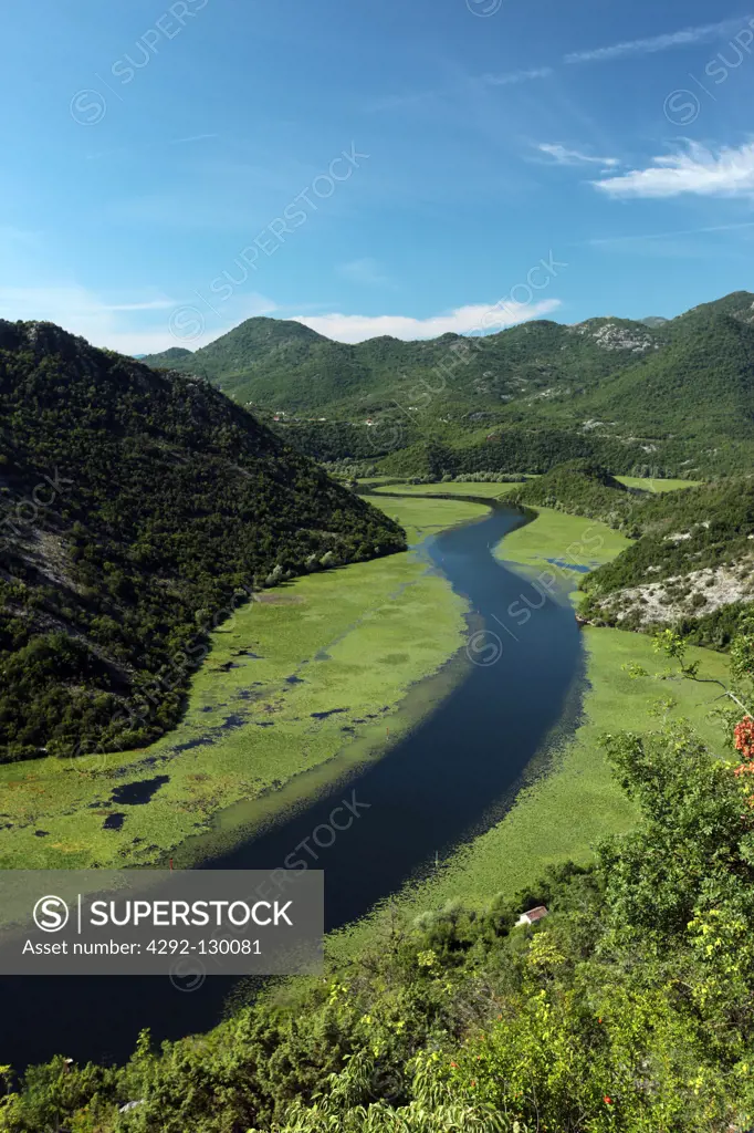 The scenery with Rijeka Crnojevica with the river Rijeka Crnojevica in the western one ends of the Skadarsko Jezero lake or Skadarsee in Centrally Montenegro in Montenegro in the Balkans at the M...