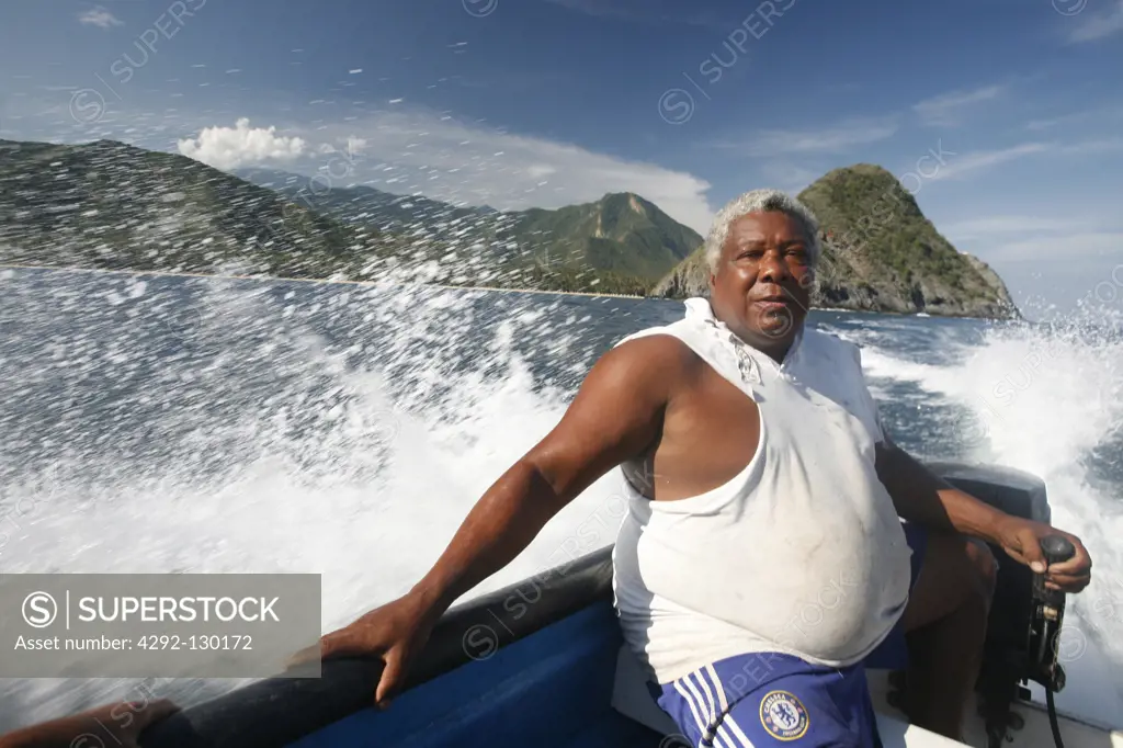 A fisherman in his Taxiboat between Choroni and Chuao in the Caribbean in Venezuela in South America.