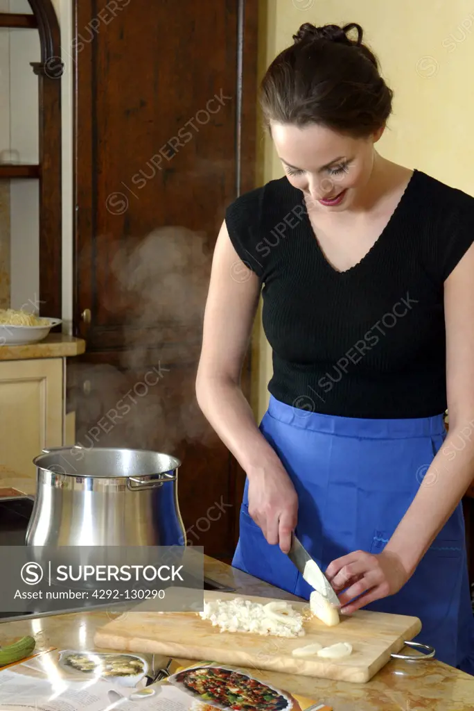 Frau schneidet Zwiebeln in der Kueche, Woman Cutting Onion in a Kitchen Cooking