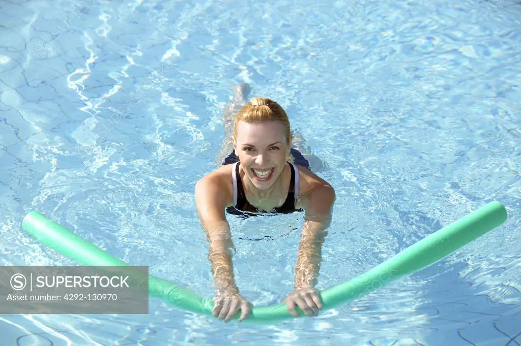 Junge Frau macht Aquaaerobic im Pool, young woman doing aquaaerobic in the swimmingpool