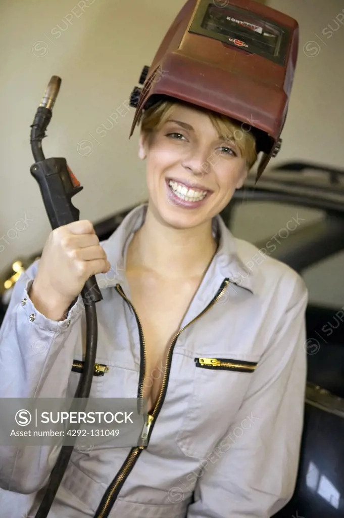 Sexy Kfz-Mechanikerin mit Schweissgeraet, young female motor mechanic at a garage doing weld