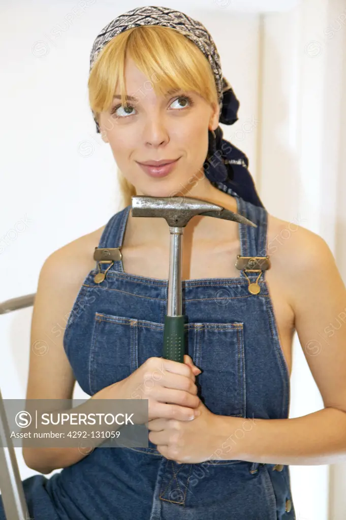 Junge Heimwerkerin in Overall mit Hammer, Beauty young woman posing with hammer