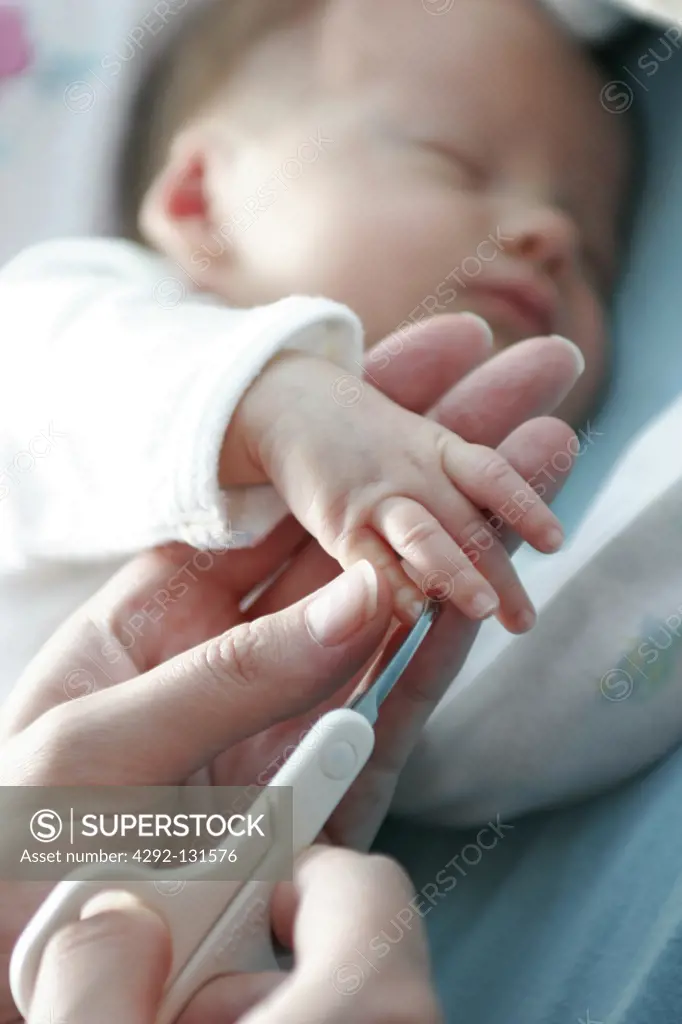 Mutter schneidet dem Baby die Fingernaegel