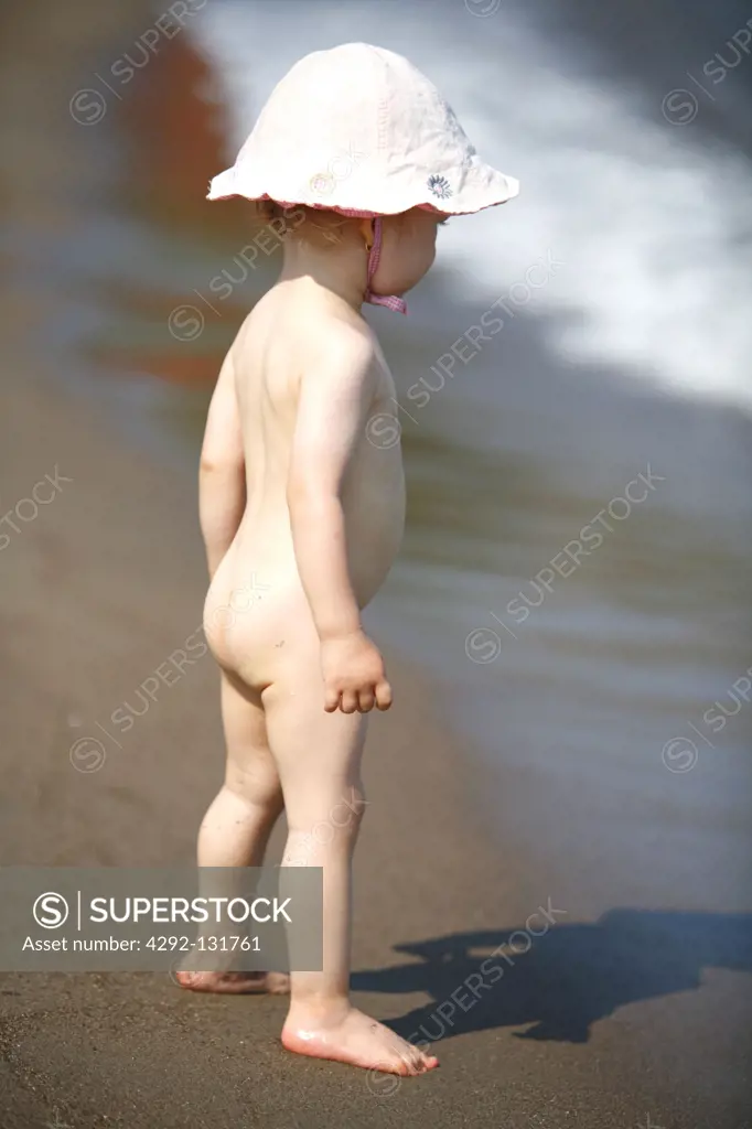 Kleinkind, Maedchen mit Sonnenhut am Strand, naked little girl on the beach