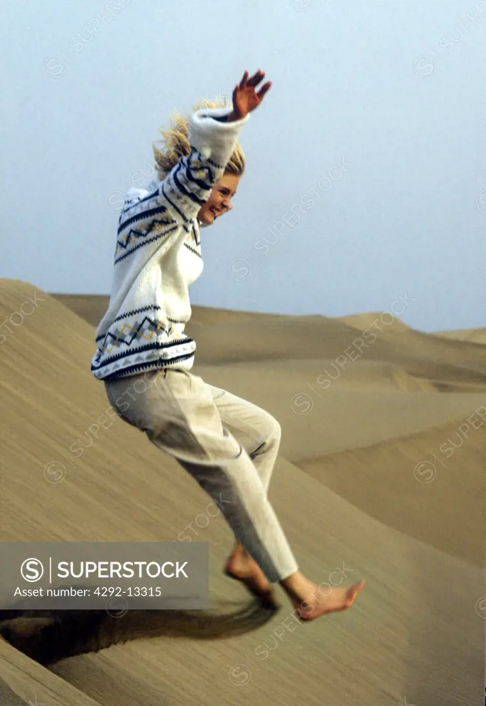 Woman jumping on desert sand