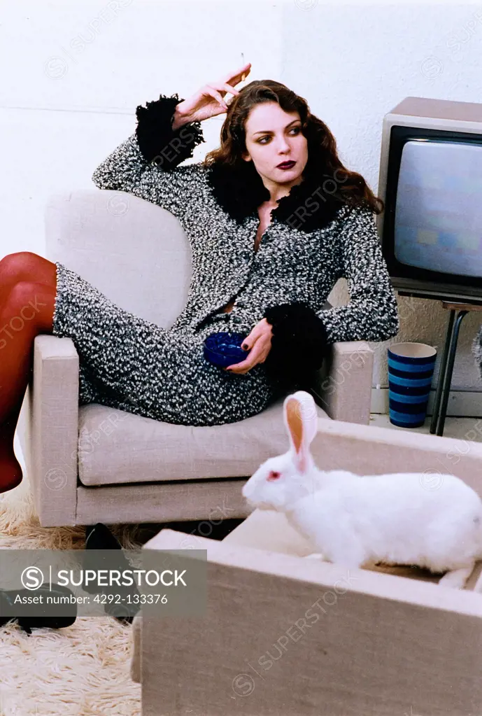 Woman and rabbit in armchairs.