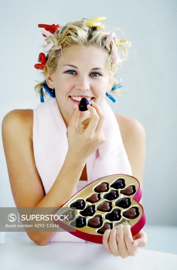 Woman taste chocolate heartshape box