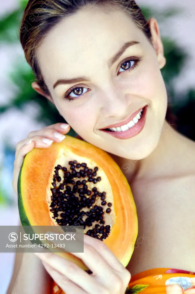 Portrait of woman with papaya in her hands