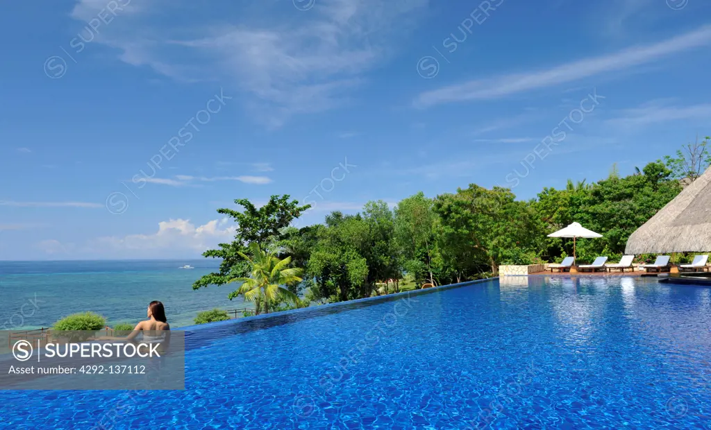Philippines, Bohol, Eskaya Beach resort, woman in swimming pool