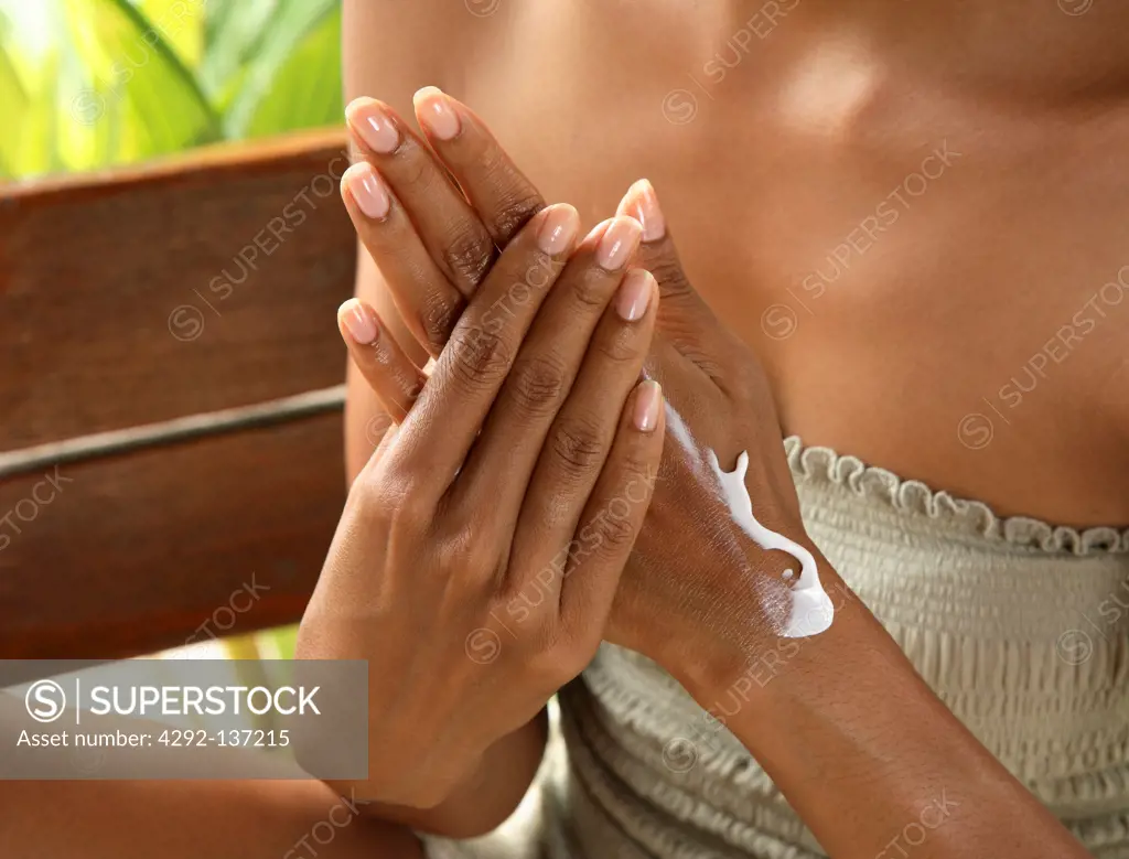 Woman applying moisturiser on hands