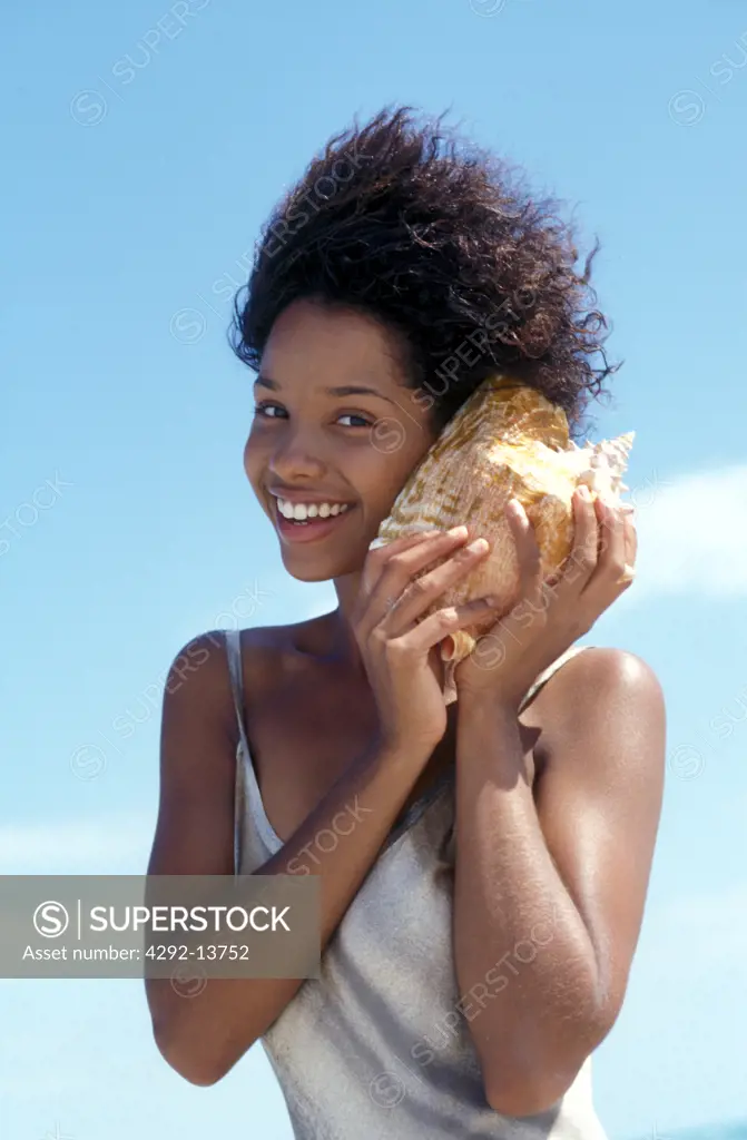 Woman on the beach with shell