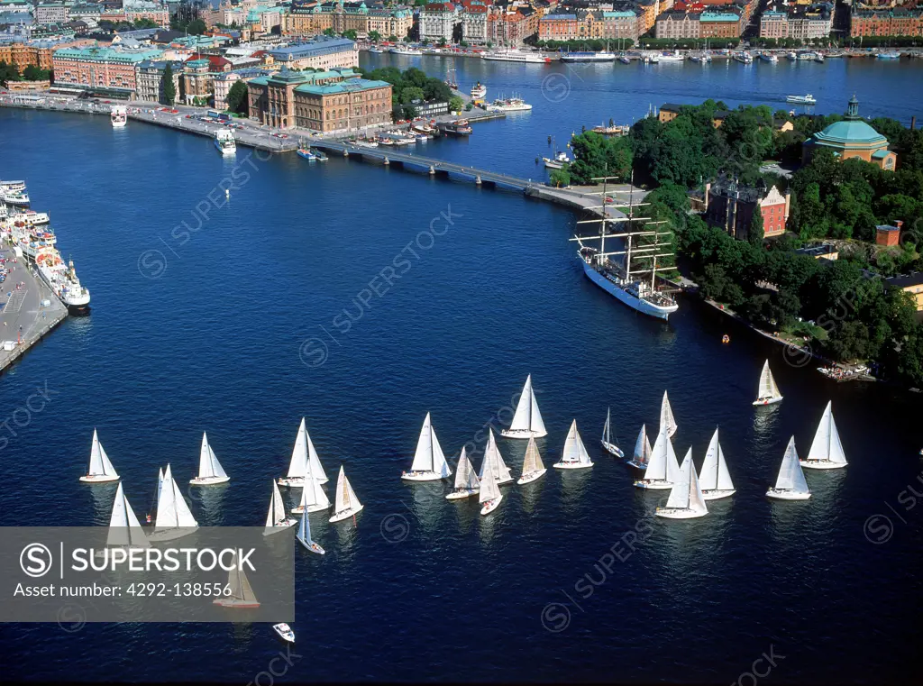 Sweden, Stockholm. Sailboat day on the Riddarfjarden w/Town Hall (Stadshuset) beyound.
