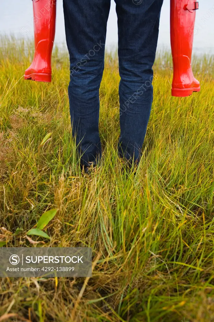 Adult carrying children in red wellington boots