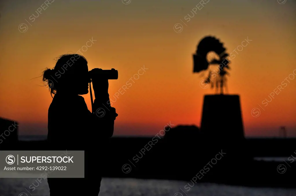 Italy, Sicily, Trapani, salt basin and windmill at sunset