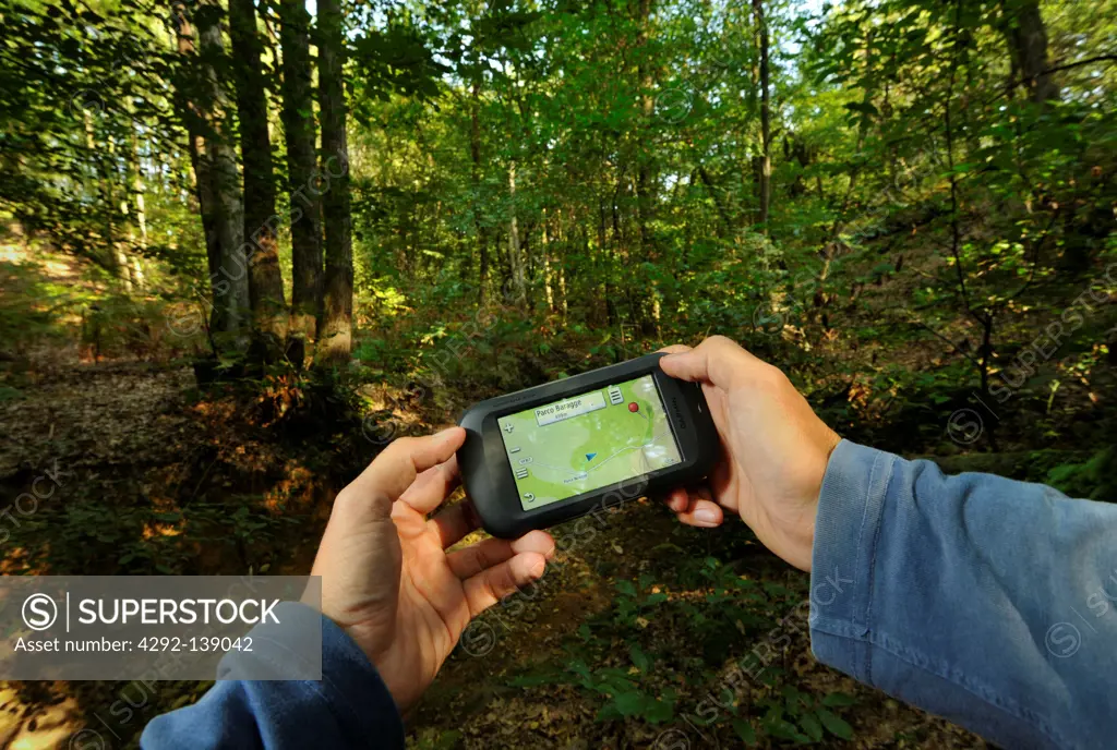 Man holding gps unit in forest