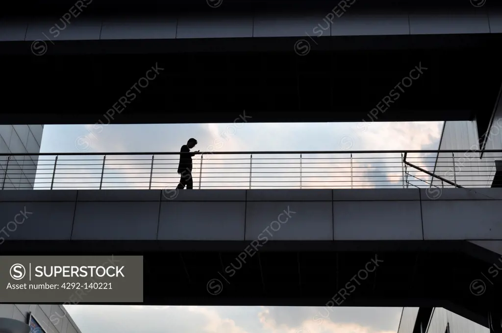 Seoul, South Korea, a man walking along a footbridge by Seoul Station