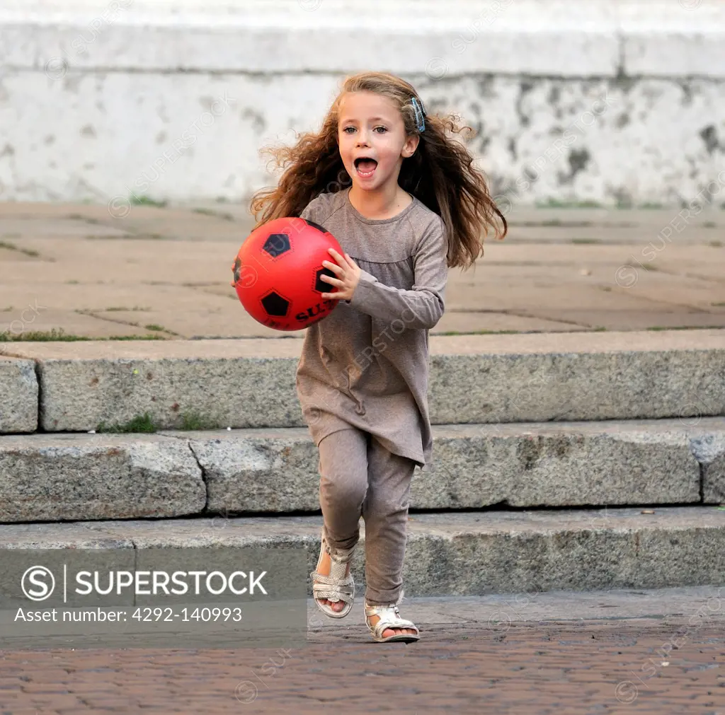Little girl run with a red ball