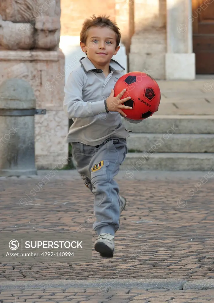 Little boy run with ball