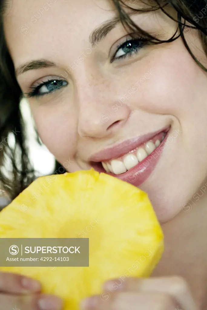 Portrait of a woman eating pineapple
