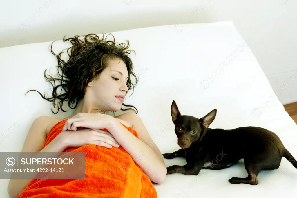 Woman lying in bed with dog