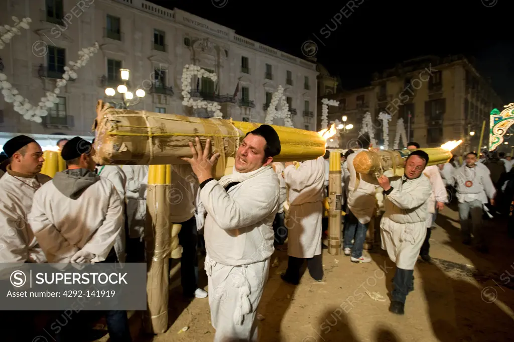 Italy, Sicily, Catania, men carrying candle during Sant'Agata Feast (the Patron Saint of the city)