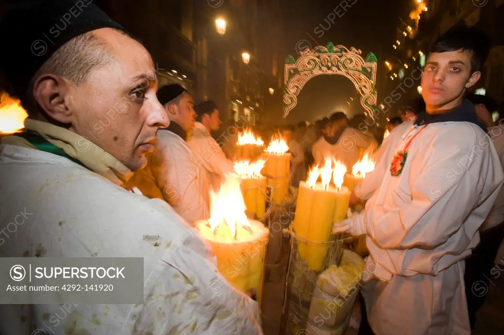 Italy, Sicily, Catania, men carrying candle during Sant'Agata Feast (the Patron Saint of the city)