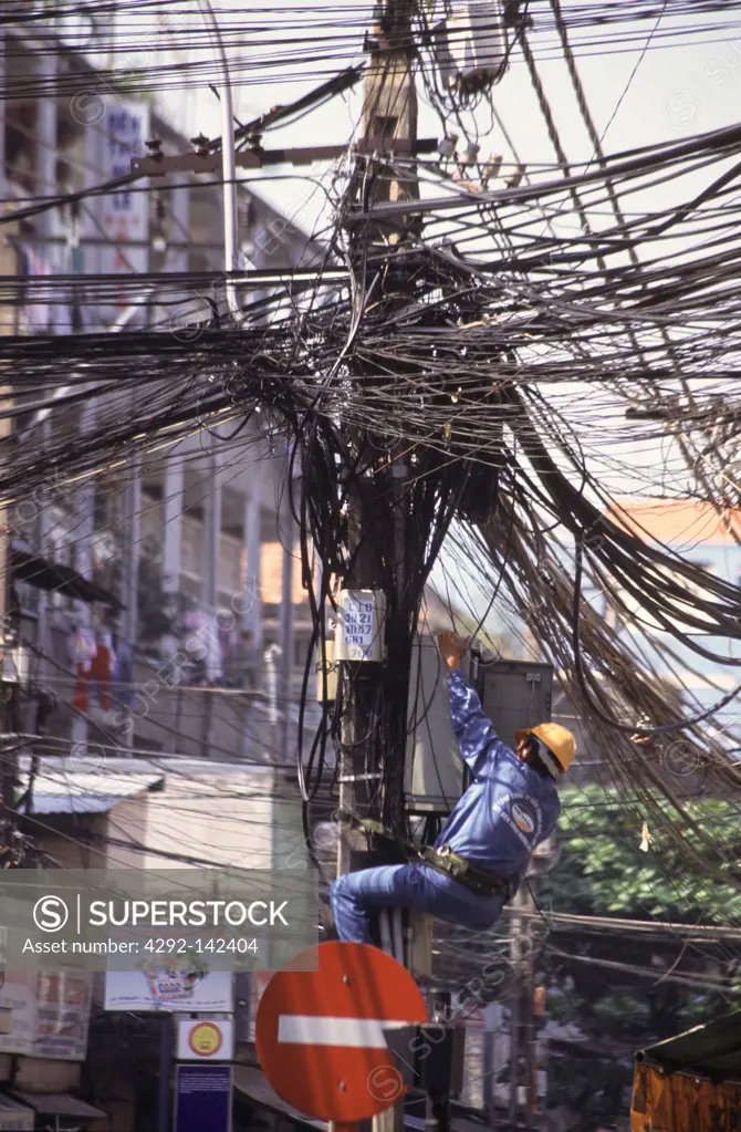 Vuetnam, Ho Chi Minh City, man working on telephone cables