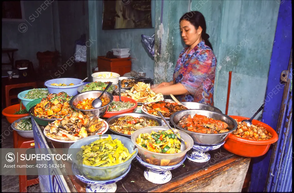 Asia, Vietnam, Hoi An, Woman preparing food at a stall in the market