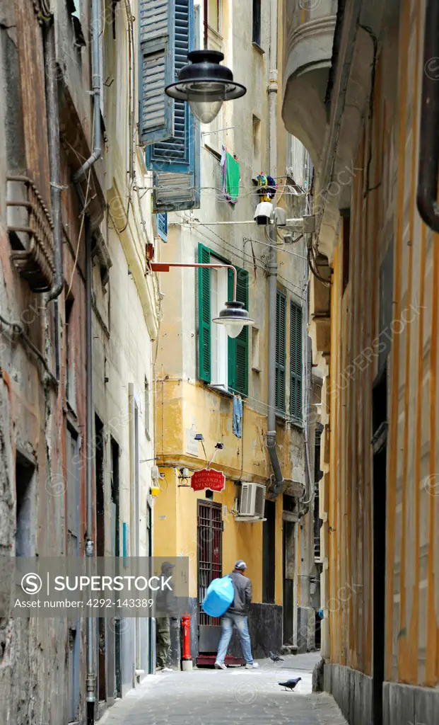 Italy, Liguria, Genoa, immigrants in old alley in historical centre