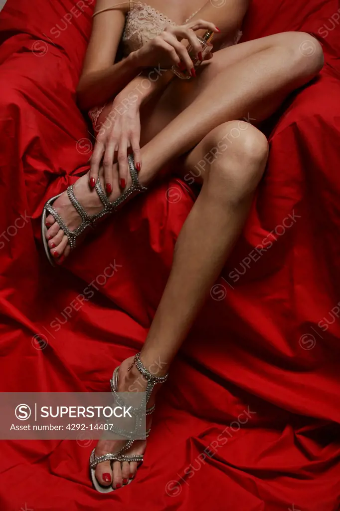 Woman in underwear applying perfume