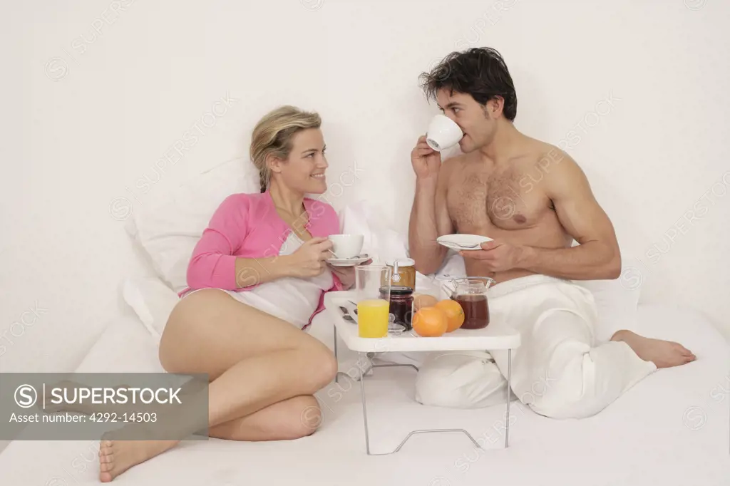 Couple having breakfast on bed