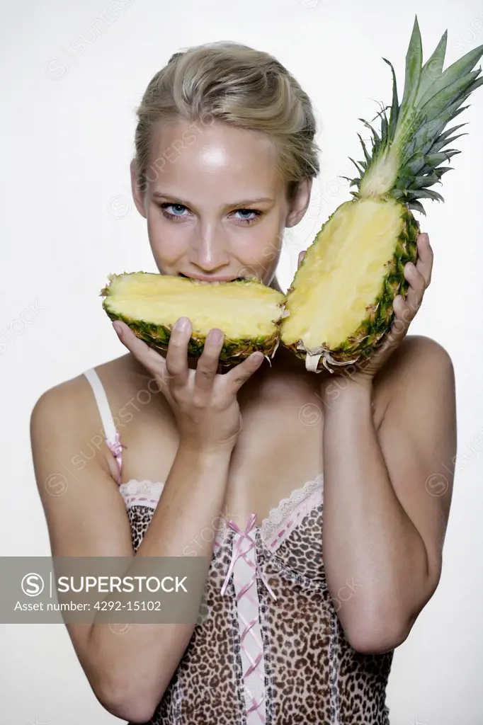 Woman's portrait biting a pineapple