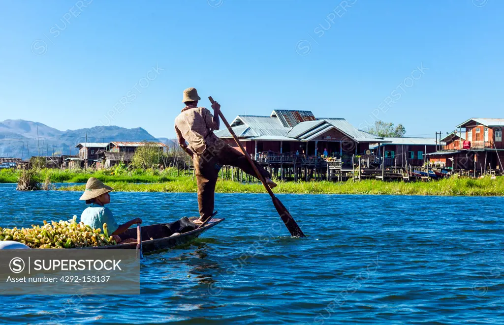 Myanmar, Shan State, a boat coming from the market with the rower performing a typical way to row on the Inla Lake.