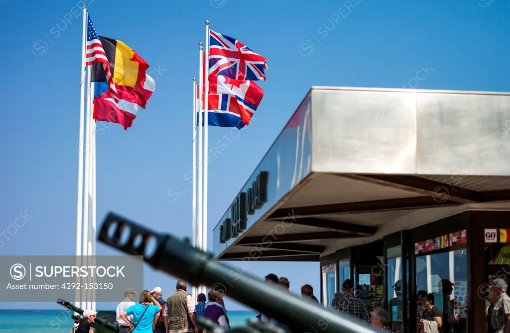 France, Normandy, Arromanches, flags and weapon in the places of the second World War landing memorial.
